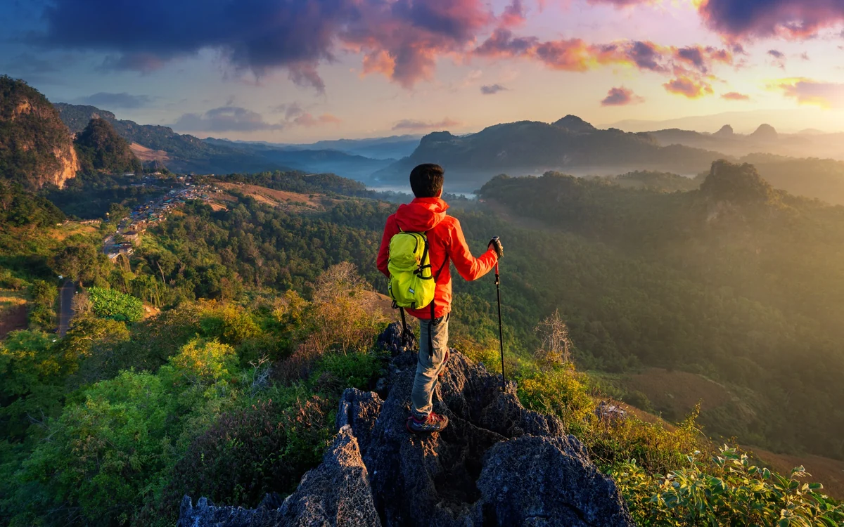 Traveller overlooking a scenic mountain destination at sunset