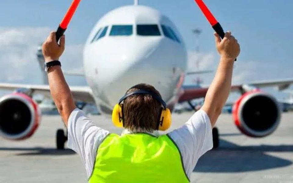 Aircraft ground handling professional guiding an aircraft on the apron